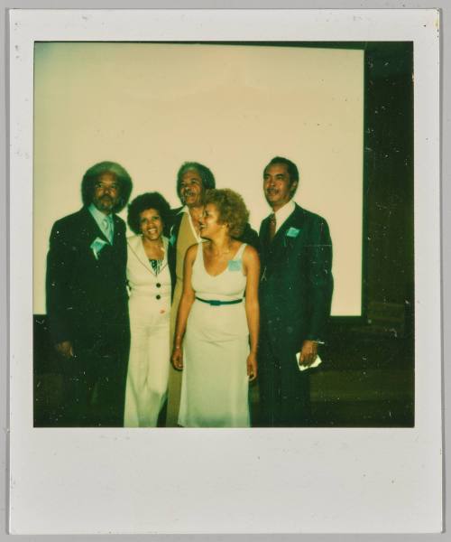 [Group of three men and two women posing in formal apparel]
