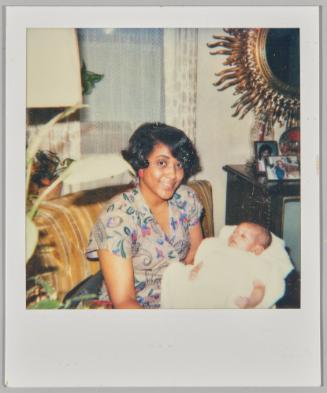 [Woman in paisley dress holding a newborn]
