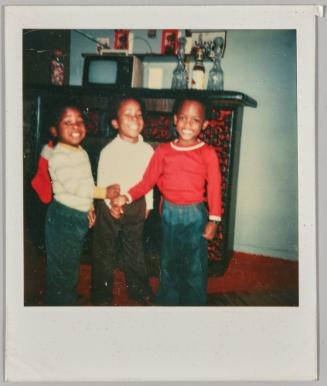 [Three young children posing with their fists touching]
