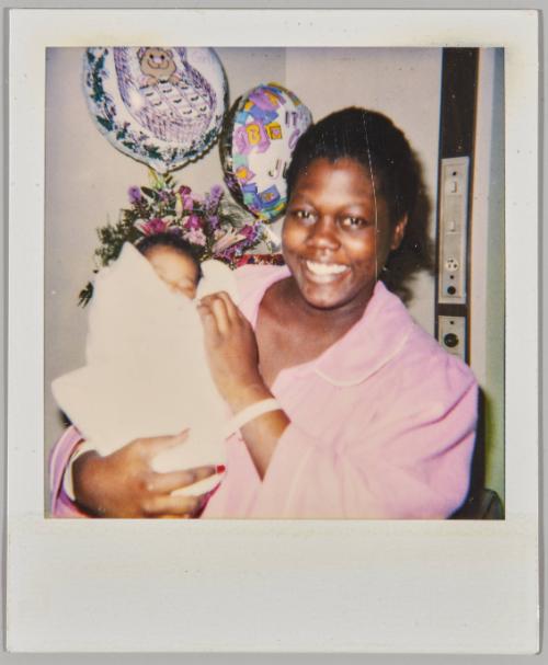 [Woman holding newborn wrapped in blanket]
