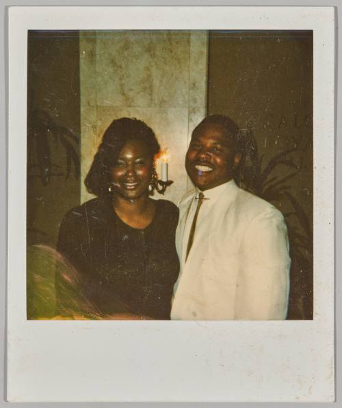 [Man and woman smiling together with candle light fixture in the background]
