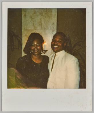 [Man and woman smiling together with candle light fixture in the background]
