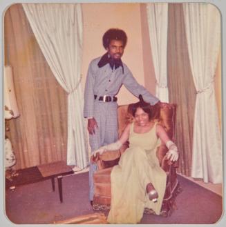 To Gloria My favourite cousin Love Michael Smith -n- Cheryl Jones Sweetheart Ball “Picture of the night” As well as the year 2/23/74 [Couple posing, woman wearing green gown sitting in chair]
