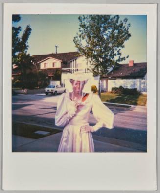 [Woman posing in wedding dress, houses in background]
