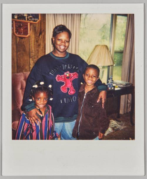 [Young woman with arms around little boy and girl wearing Sesame Street sweatshirt]

