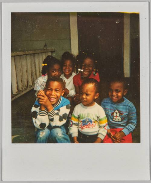 [Three girls and three boys sitting together and smiling on porch]
