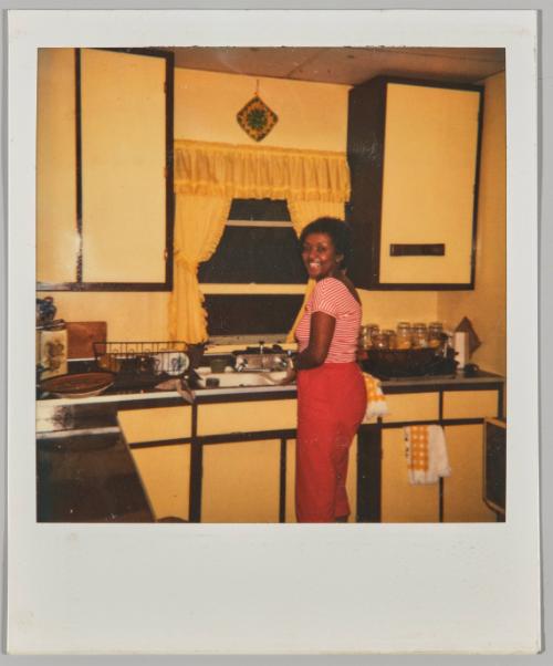 Pat - July 4, 1981 [Woman smiling washing dishes in kitchen sink]