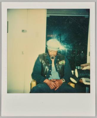 [Man sleeping upright in front of window at night]
