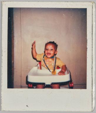 [Baby in highchair with soother fastened around neck]
