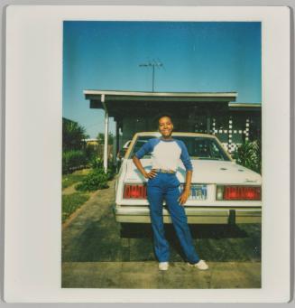 [Young woman posing in front of white car with California license plate]
