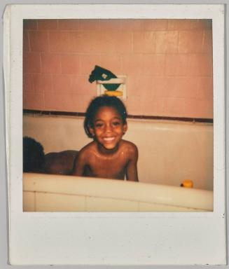 [Child in bathtub smiling]
