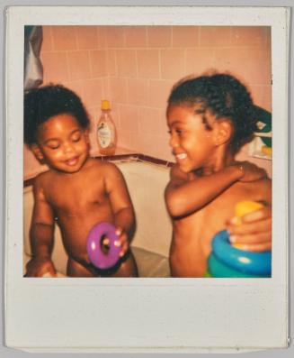 [Two children playing with toys in bathtub]
