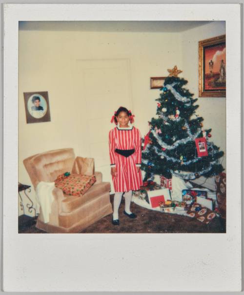 [Girl in pinstriped red dress in living room with Christmas tree]
