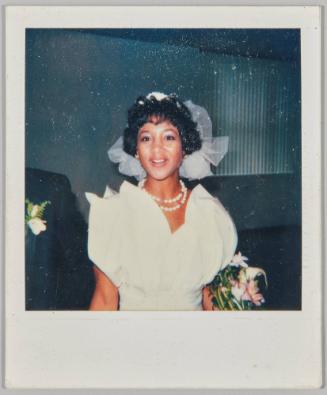 [Woman in wedding dress holding white and pink flowers]
