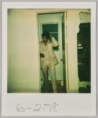 6-2-78 [Young man in tan suit standing in doorway fixing his hair]