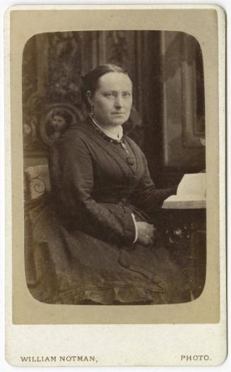 [Woman seated with book]