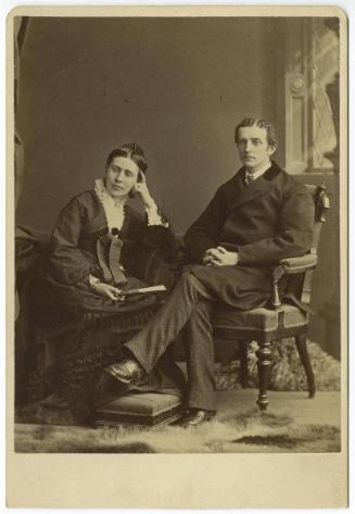 [Couple seated on two chairs]