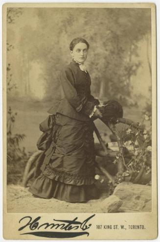 [Young woman with big eyes posed in faux outdoor scene]