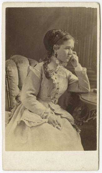 [Seated woman with one long curl, pensive]