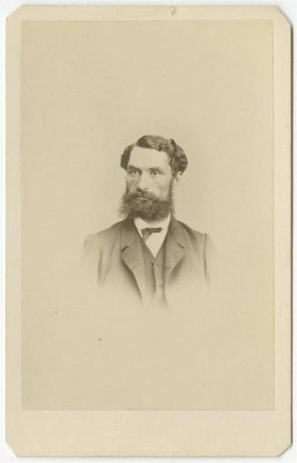 [Young bearded man with buttoned coat]