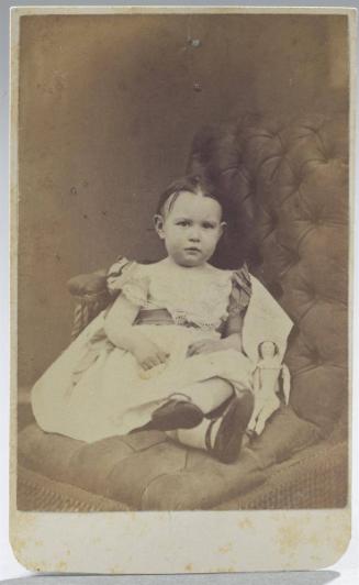 Young girl seated with a doll