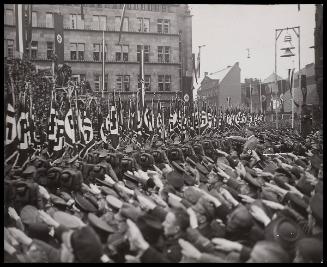 Hitler saluting marching troops.