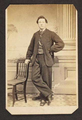 Unknown sitter [portrait of a standing man with a chair]