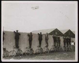 Cyclists watching an Aviation Meeting in Hendon.