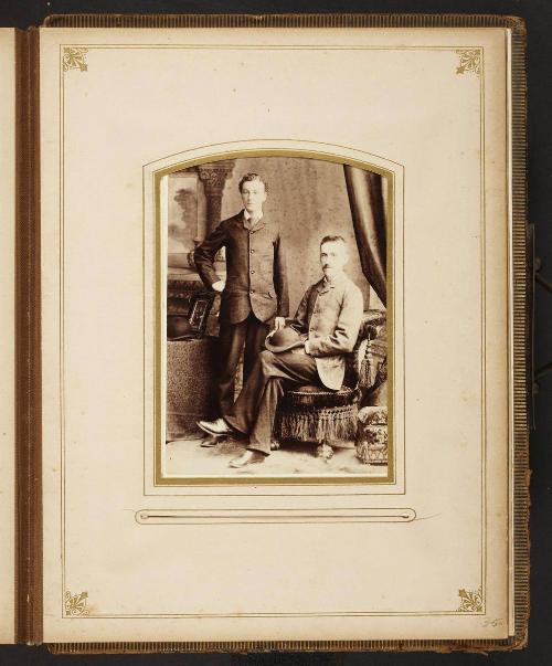 Unknown sitters [portrait of standing man and a seated man with hat on lap]