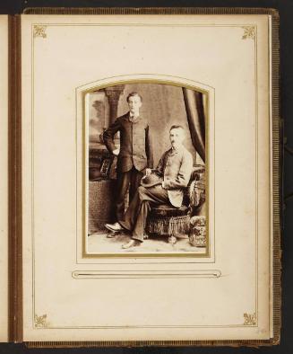 Unknown sitters [portrait of standing man and a seated man with hat on lap]