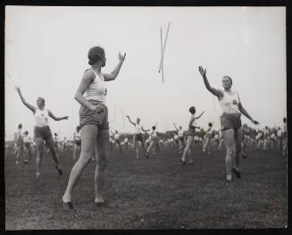 Sports day girls throwing batons to each other.