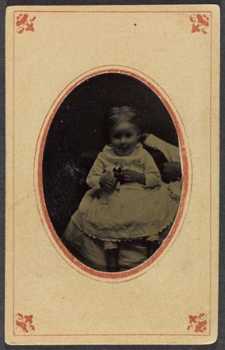 Portrait of a young girl with doll (seated on lap of cropped figure)