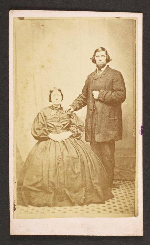 Unknown sitters  [portrait of a seated woman and standing man, with his right hand on woman's left shoulder]