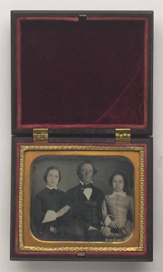 Portrait: Man with two young women, holding cased images