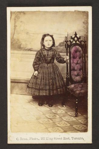 Unknown sitter [portrait of a standing girl holding on to an upholstered chair]