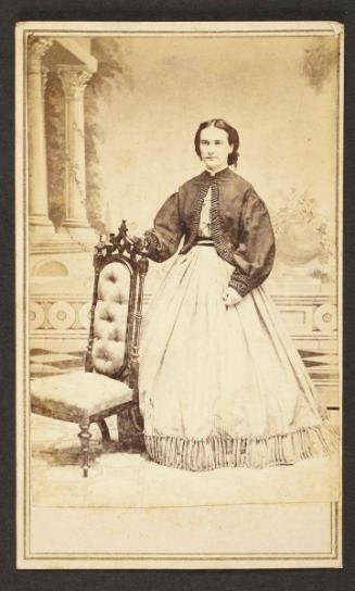 Unknown sitter [portrait of a standing woman holding on to an upholstered chair]