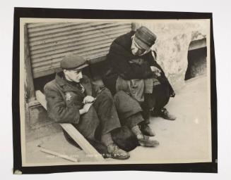 Two men sitting on street