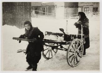 Two women pushing cart through snow