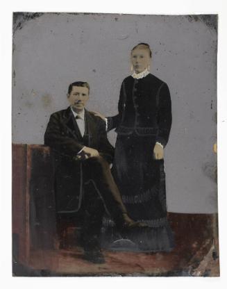 [Seated man and standing woman]