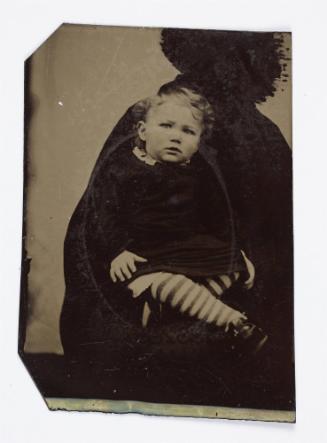 Portrait of young child with striped stockings (seated on lap supported by defaced figure)