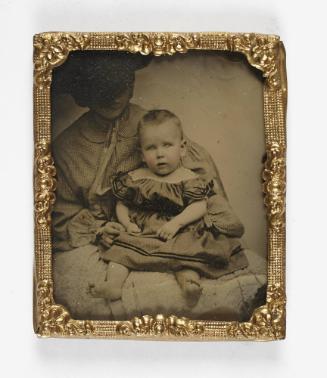 Portrait of young boy in dress with white collar (seated on lap of woman defaced)