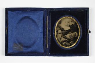 Portrait of baby with white bib (seated on lap of cropped figure)