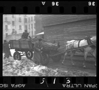 Ghetto policemen or postal worker transporting goods on a horse-drawn wagon in winter