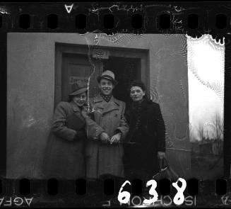 A man and two women in front of a door to Room # 1-6