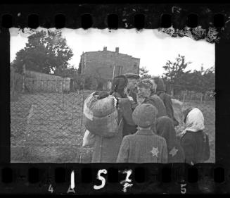 Line-up of residents behind the prison fence prior to deportation