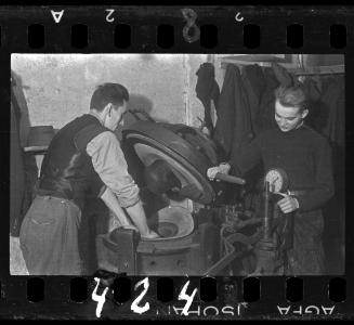 Two men making hats in a factory in the ghetto