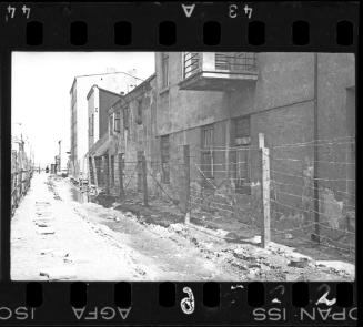 Street view of buildings with barbed-wire fencing in the Baluty area