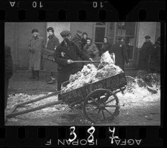 Man shovelling snow onto cart