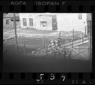 Two Jewish policemen standing at an entry gate in the ghetto