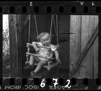A boy in a doorway swing